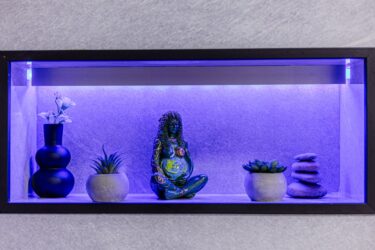 Shelf with decorative items and purple lighting